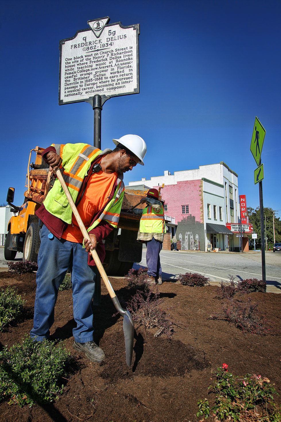 Grounds maintenance employee working in median