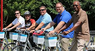 Photo of City Council members posing on bikes at ribbon cutting ceremony. 