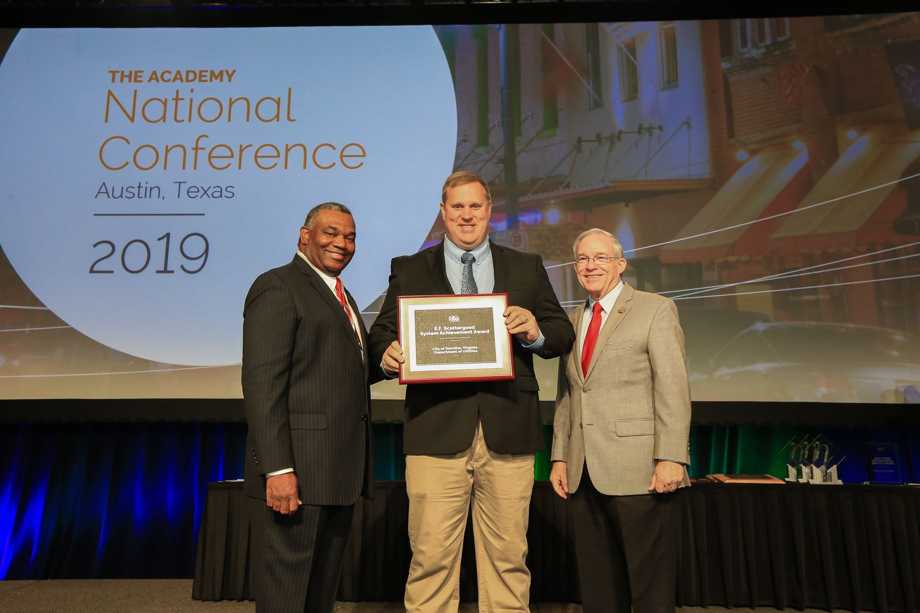 Danville Utilities Director Jason Grey, center, accepts the award from APPA Chairman Decosta Jenning