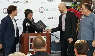 Bettina K. Ring, secretary of agriculture and forestry, presents state flag to AeroFarms officials