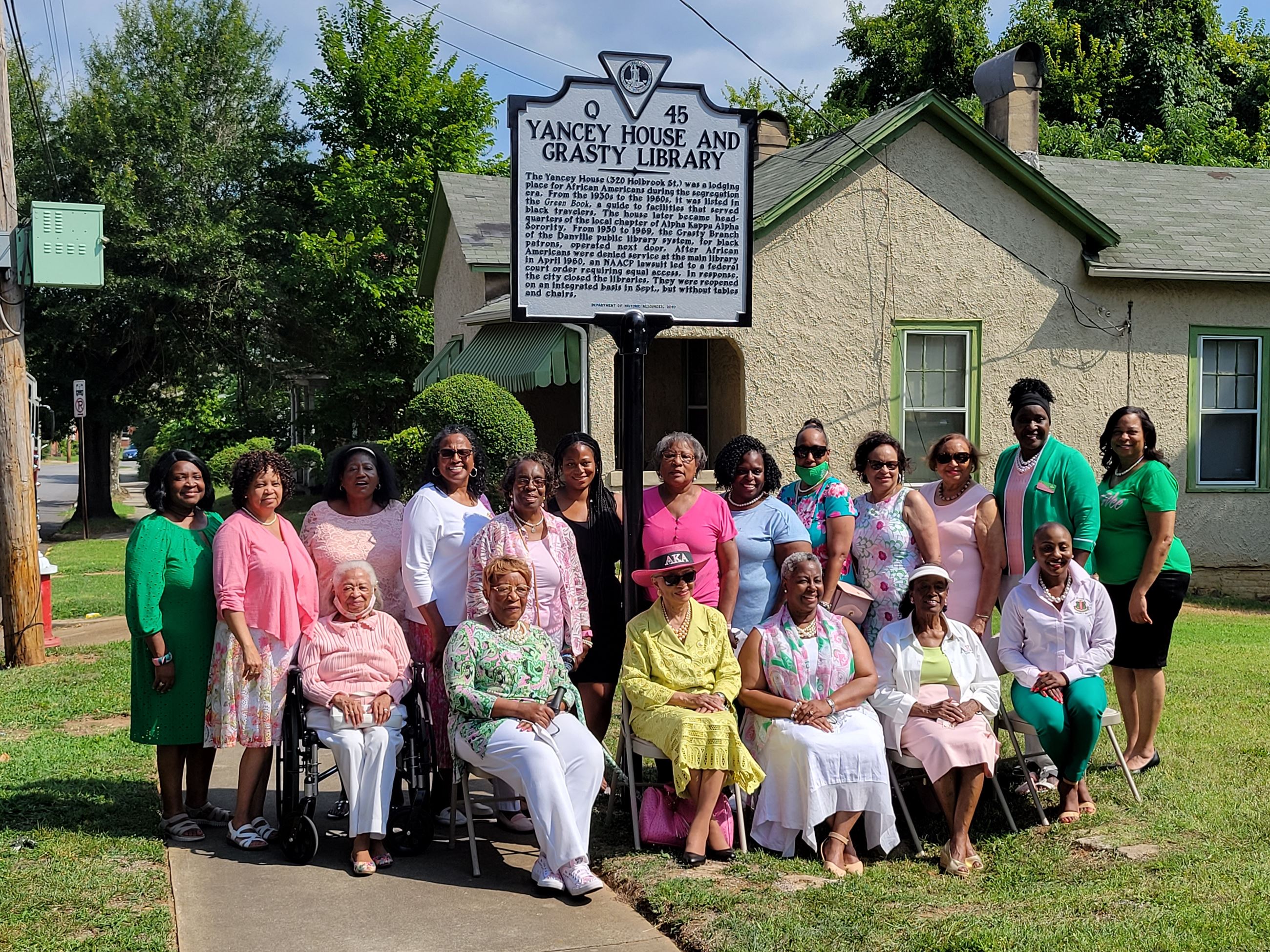 Members of the local chapter of Alpha Kappa Alpha Sorority pose under the marker. 