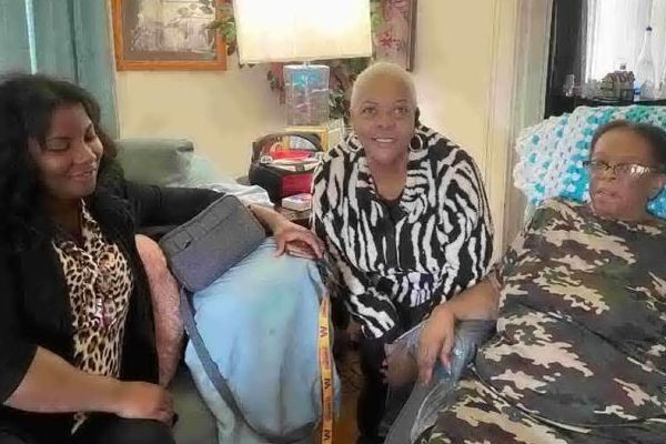 Nonprofit Launches Revitalization Effort story cover photo showing Wendi and two residents sitting in a home.